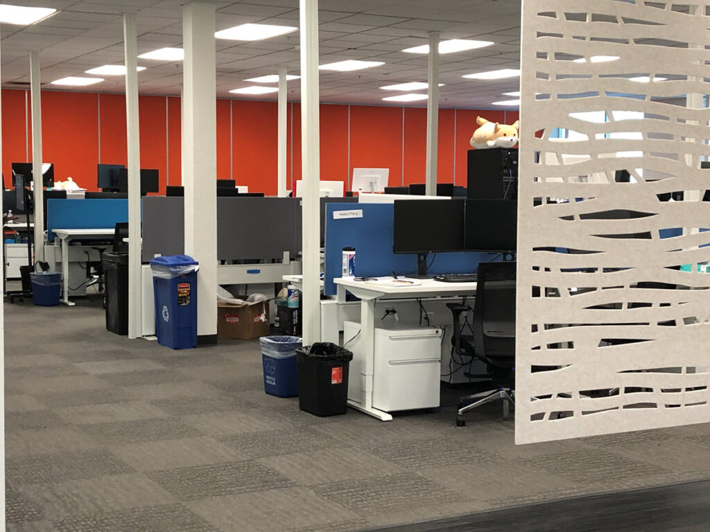 Commercial office with height-adjustable workstations, privacy panels, monitor systems and collaborative space designed around employee workflow and efficient space planning.